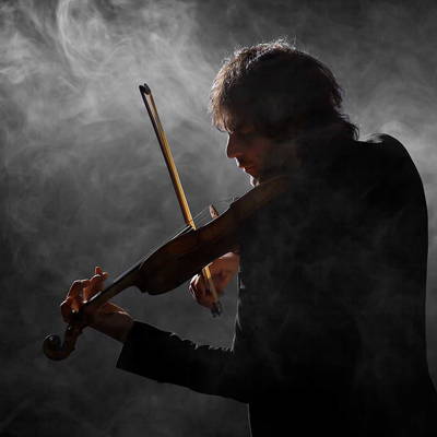Violinist playing in a dark, smoky room