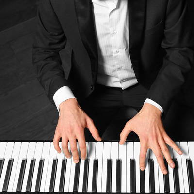 Pianist’s hands playing a piano keyboard