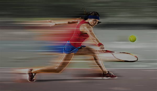 Tennis player lunging for a ball in a motion-blurred shot