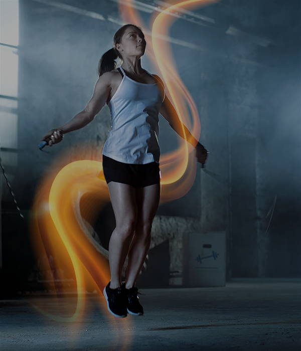 Woman jumping rope surrounded by glowing orange light trails