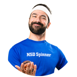 Smiling man in a white headband and blue NSD Spinner shirt holding a small ball