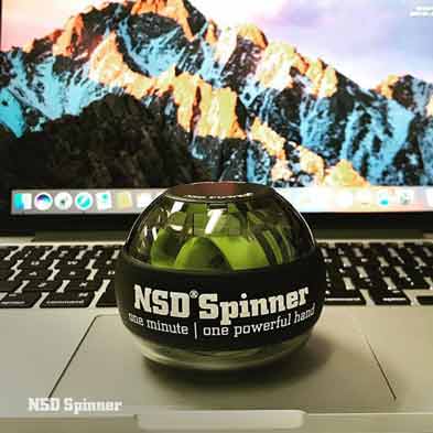 Green NSD Spinner resting on a laptop keyboard