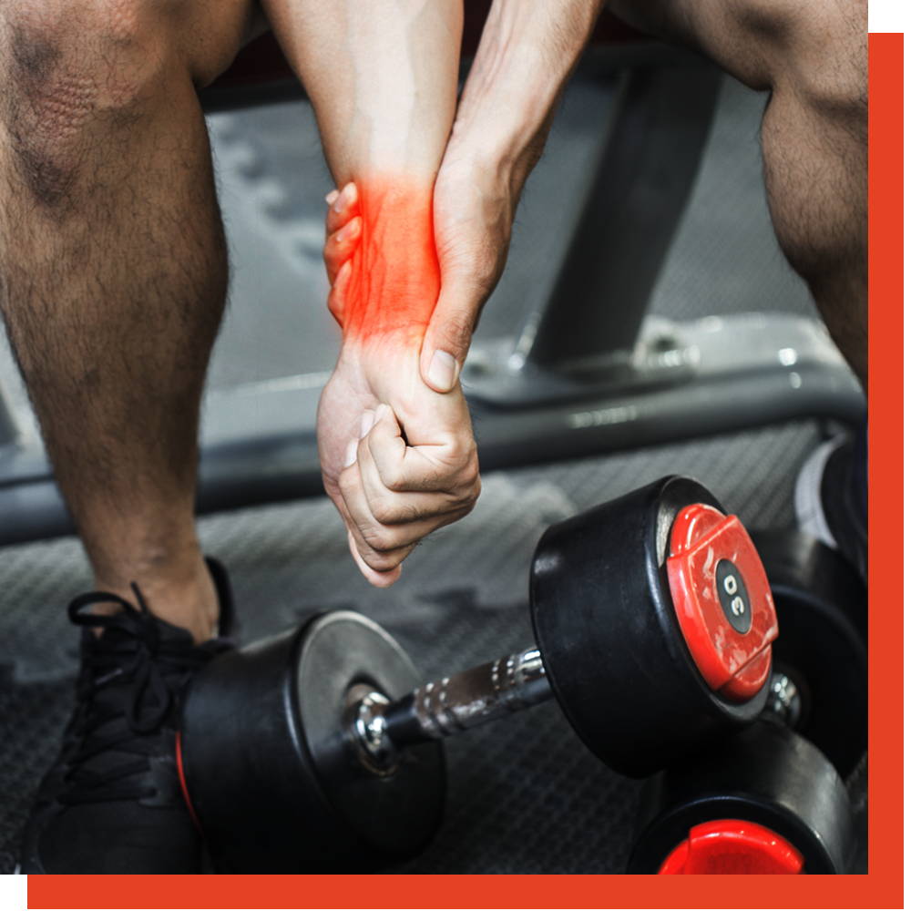 Man gripping his painful wrist next to a dumbbell at the gym